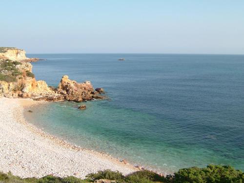 a view of a beach with rocks and the ocean at Casa Luana - Rooms in Sagres