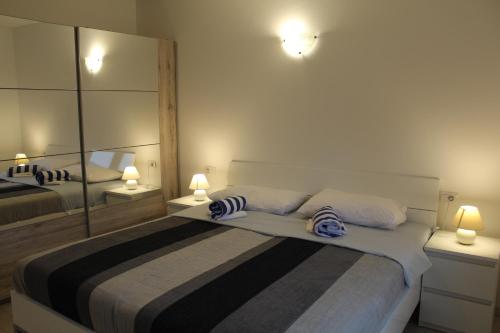 - une chambre avec 2 lits et un grand miroir dans l'établissement Casa Rados Fazana, à Fažana