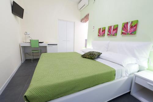 a white bedroom with a green blanket on a bed at Affittacamere Dune Blu in Riomaggiore