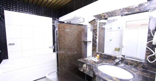 W łazience znajduje się umywalka, toaleta i lustro. w obiekcie Hayat Jazan Furnished Units w mieście Dżizan