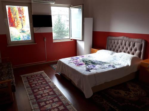 a bedroom with a bed and two windows at mai AK pansiyon in Çınarcık