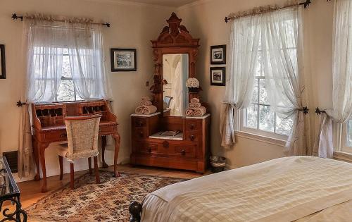 a bedroom with a bed and a desk and a mirror at The Patrician Hollywood Universal in Pasadena