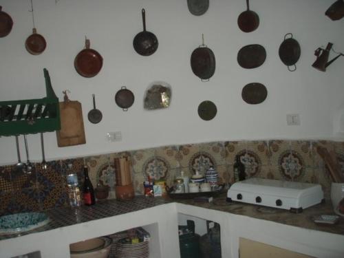 una cucina con pentole e padelle appese al muro di Casa Madonia a Panarea
