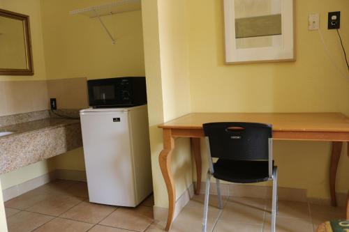 a small kitchen with a table and a small refrigerator at Great Western Inn in Pasadena