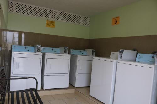 a laundry room with washing machines and a chair at Great Western Inn in Pasadena