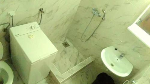 a white bathroom with a toilet and a sink at Apartmani Bosco in Tivat