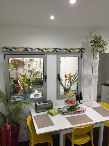 a kitchen with a table with yellow chairs and a window at Casa Physalis in Ponta Delgada
