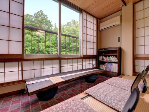 a room with a bench and a window at Kashiwaya Ryokan in Tenei