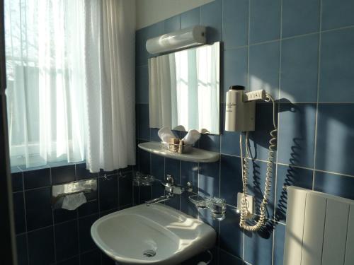 uma casa de banho azul com um lavatório e um espelho em Hotel Adler em Stein am Rhein