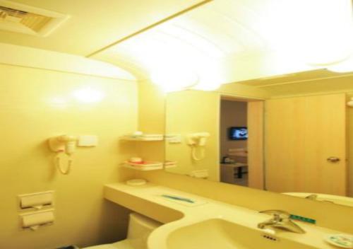 a bathroom with a sink and a large mirror at Jinjiang Inn Sanya International Shopping Center Seaview in Sanya