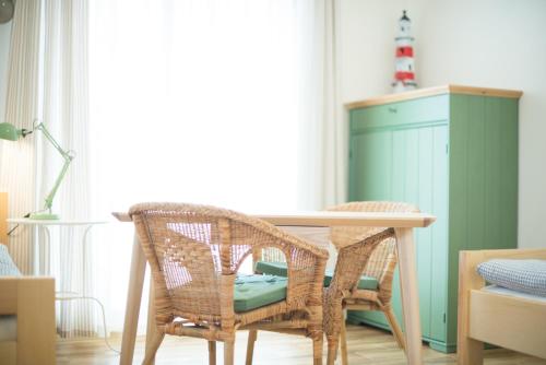 a dining room with a table and wicker chairs at Apartmány Lea in Liptovský Mikuláš