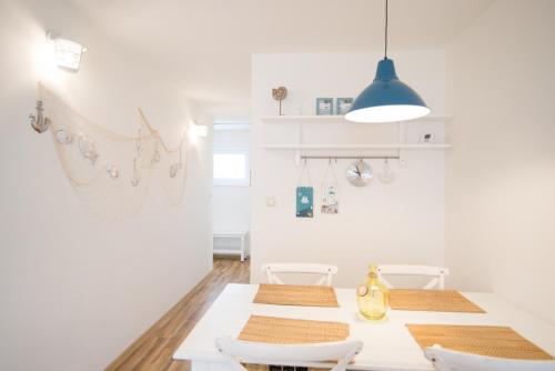 a white dining room with a table and chairs at Apartmány Lea in Liptovský Mikuláš