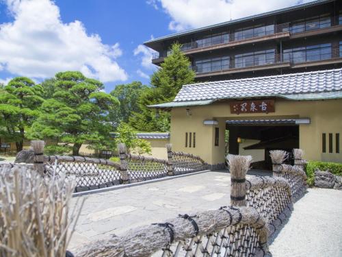 a building with a stone fence in front of it at Motoyu Kosenkaku in Kobe