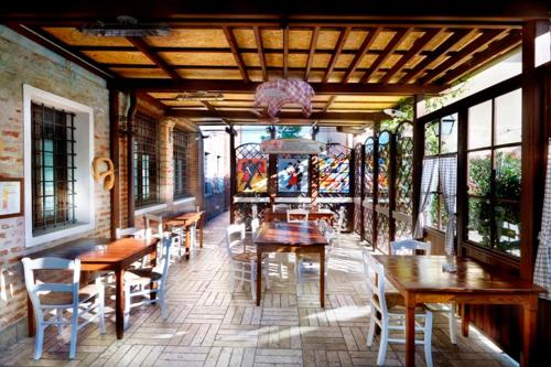 Al Gallo Nero في Borgoricco: مطعم بطاولات وكراسي خشبية ونوافذ