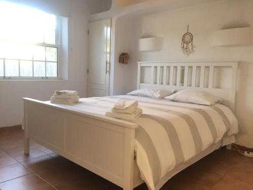 a bedroom with a large white bed with towels on it at Quinta da Balaia 3 Rooms in Albufeira