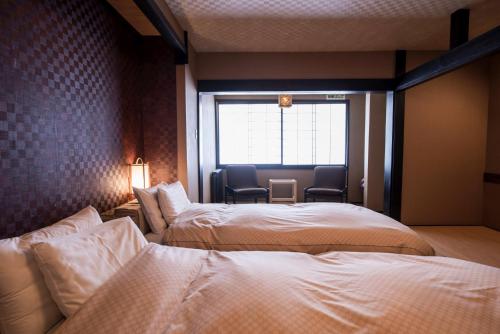 Postel nebo postele na pokoji v ubytování Takamiya Ryokan Miyamaso