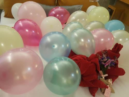 un montón de globos en una mesa con un montón de flores en The Now Hotel - SHA Extra Plus, en Jomtien Beach