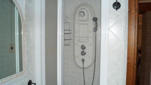 una doccia con tubo fissato a un muro di B&B La Casa Rosa a Balze