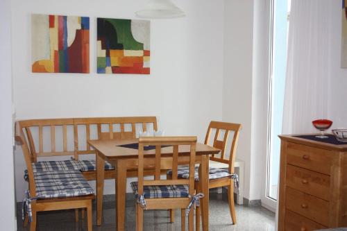 une table à manger et des chaises avec un tableau mural dans l'établissement Ferienwohnung Arlberg, à Dalaas