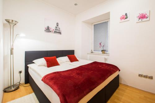 een slaapkamer met een groot wit bed met rode kussens bij Bella Donna in Maribor