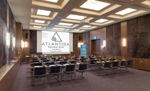 a conference room with tables and chairs and a screen at Atlantida Boutique Hotel in Rogaška Slatina