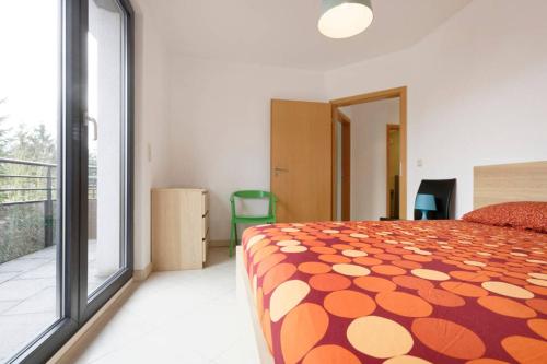 a bedroom with a bed with an orange and white blanket at Rooftop Luxembourg Ville in Luxembourg