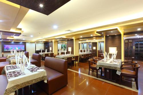 a restaurant with tables and chairs in a room at Trichur Towers in Trichūr