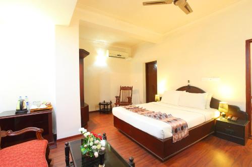 a bedroom with a bed and a chair in it at Trichur Towers in Trichūr