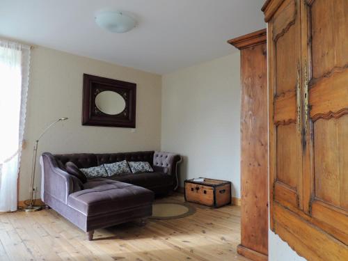 a living room with a couch and a wooden door at L'ANCIENNE FORGE in Gaillac-dʼAveyron