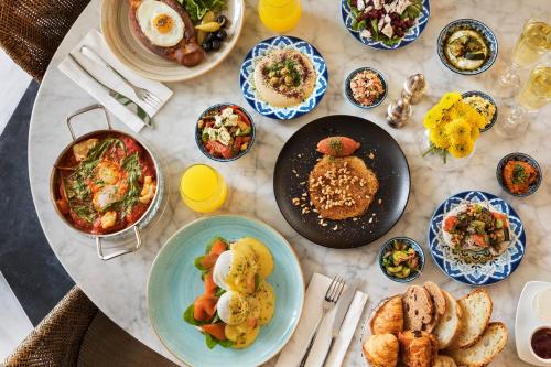 a table with plates of food on a table at Brown Beach House Tel-Aviv, a member of Brown Hotels in Tel Aviv