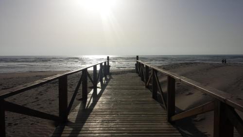 a wooden boardwalk leading to the ocean on a beach at Hostal Brisas de Conil in Conil de la Frontera