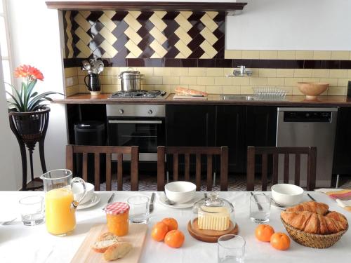 - une cuisine avec une table, du pain et du jus d'orange dans l'établissement maison a maureillas, à Maureillas