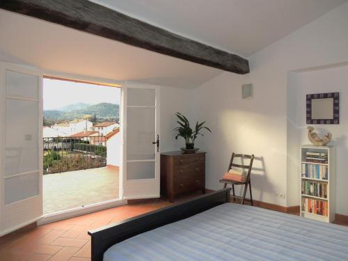 une chambre avec un lit et une grande fenêtre dans l'établissement maison a maureillas, à Maureillas