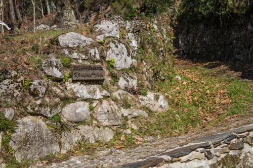 a sign on the side of a stone wall at Casa do Coentral a sua casa Rustica in Lousa