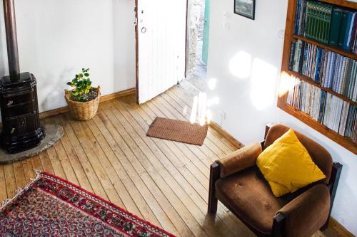 a living room with a chair with a yellow pillow at Casa do Coentral a sua casa Rustica in Lousa