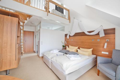 ヴァンゲン・イム・アルゴイにあるallgovia hotel garniのベッドルーム(白い大型ベッド1台、青い椅子付)