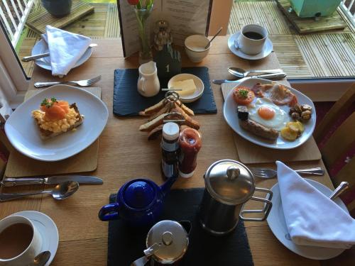 un tavolo di legno con sopra piatti di cibo per la colazione di Rothay House ad Ambleside