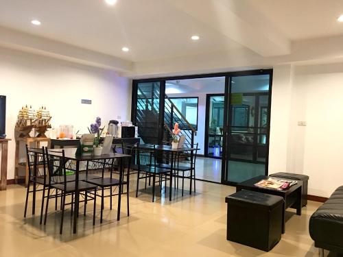 a living room with black chairs and a table at Double DD House at MRT Sutthisarn in Bangkok