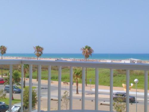 a balcony with a view of a parking lot and the beach at Apartamento Dos Faros in Conil de la Frontera