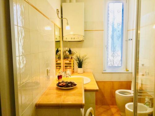 a bathroom with a sink and a bowl of fruit on a counter at Una finestra sul mare in Cogoleto