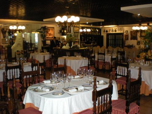 ein Esszimmer mit einem Tisch mit Tellern und Weingläsern in der Unterkunft Hotel Terraza Carmona in Vera