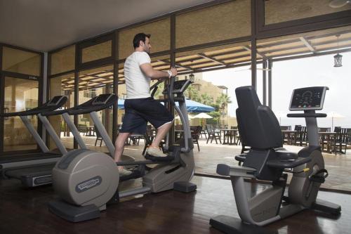 a man running on a treadmill in a gym at Samarah Resort D44 in Sowayma