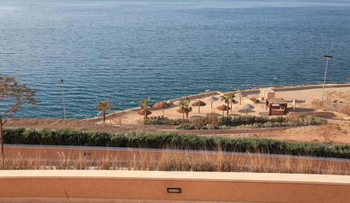 a view of a beach with palm trees and the water at Samarah Resort D44 in Sowayma
