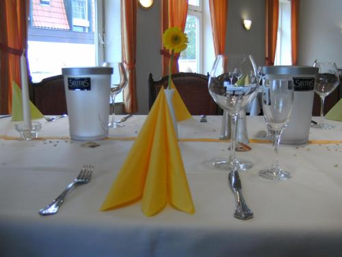 a table with a white table cloth with wine glasses and napkins at Hotel Seelust in Hohwacht