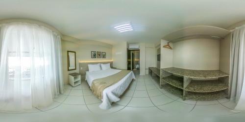 a bedroom with a bed and a desk in a room at Pousada Doluar in Penha