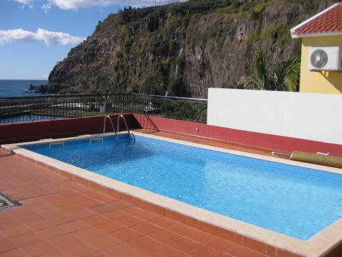 a swimming pool with a view of the ocean at Casa Maresia in Ponta do Sol