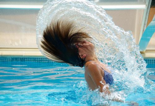 Dziewczyna w basenie z włosami w wodzie w obiekcie Gdańsk-Apartament Jaglana Spa w Gdańsku