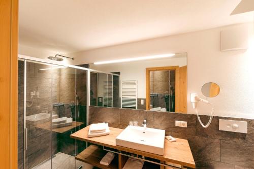a bathroom with a sink and a shower at Hotel Foestlerhof in Villa Ottone
