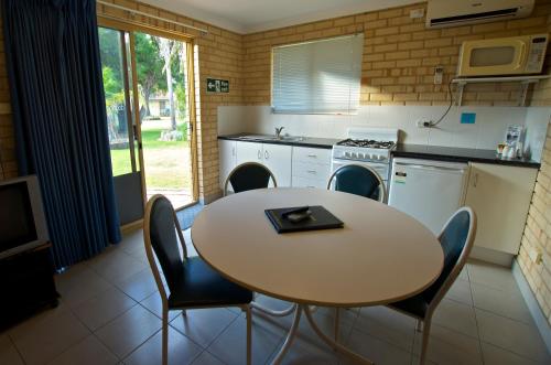 a kitchen with a table and a table and chairs at Esperance Beachfront Resort in Esperance