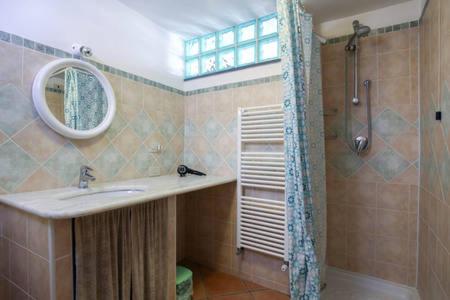 un bagno con lavandino, specchio e doccia di The Cottage ad Agerola